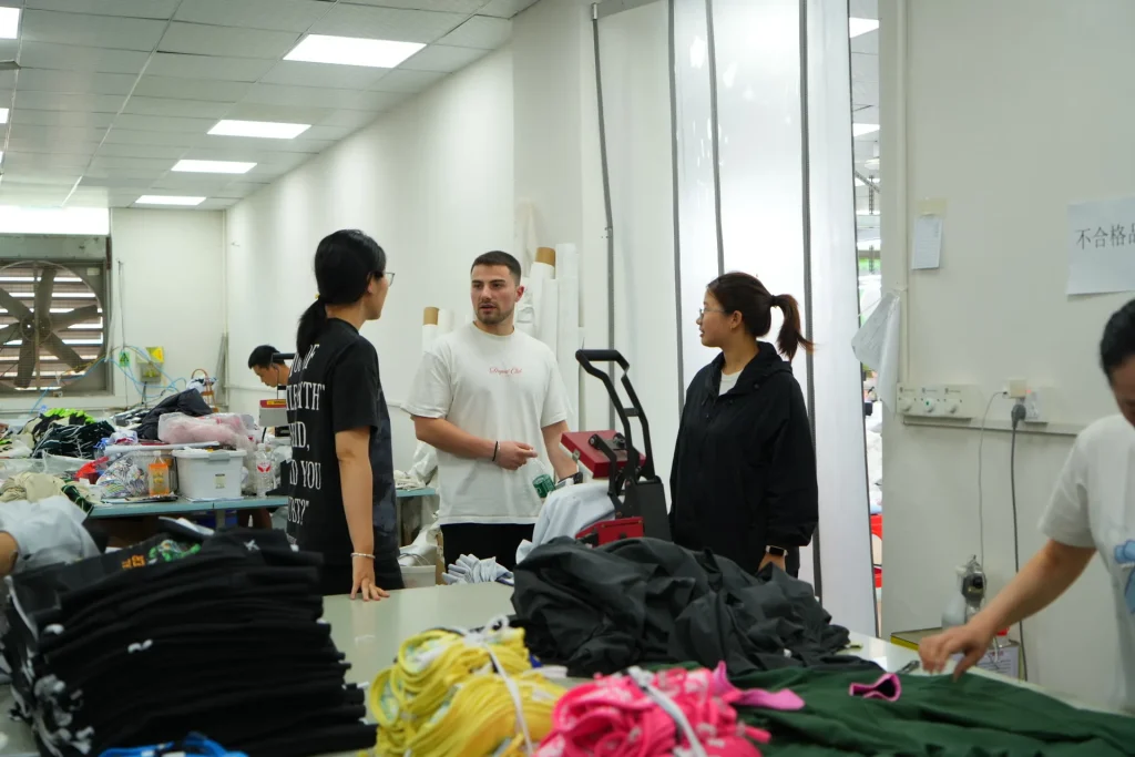 Factory visitor reviewing apparel production activity with the Eking Clothing team