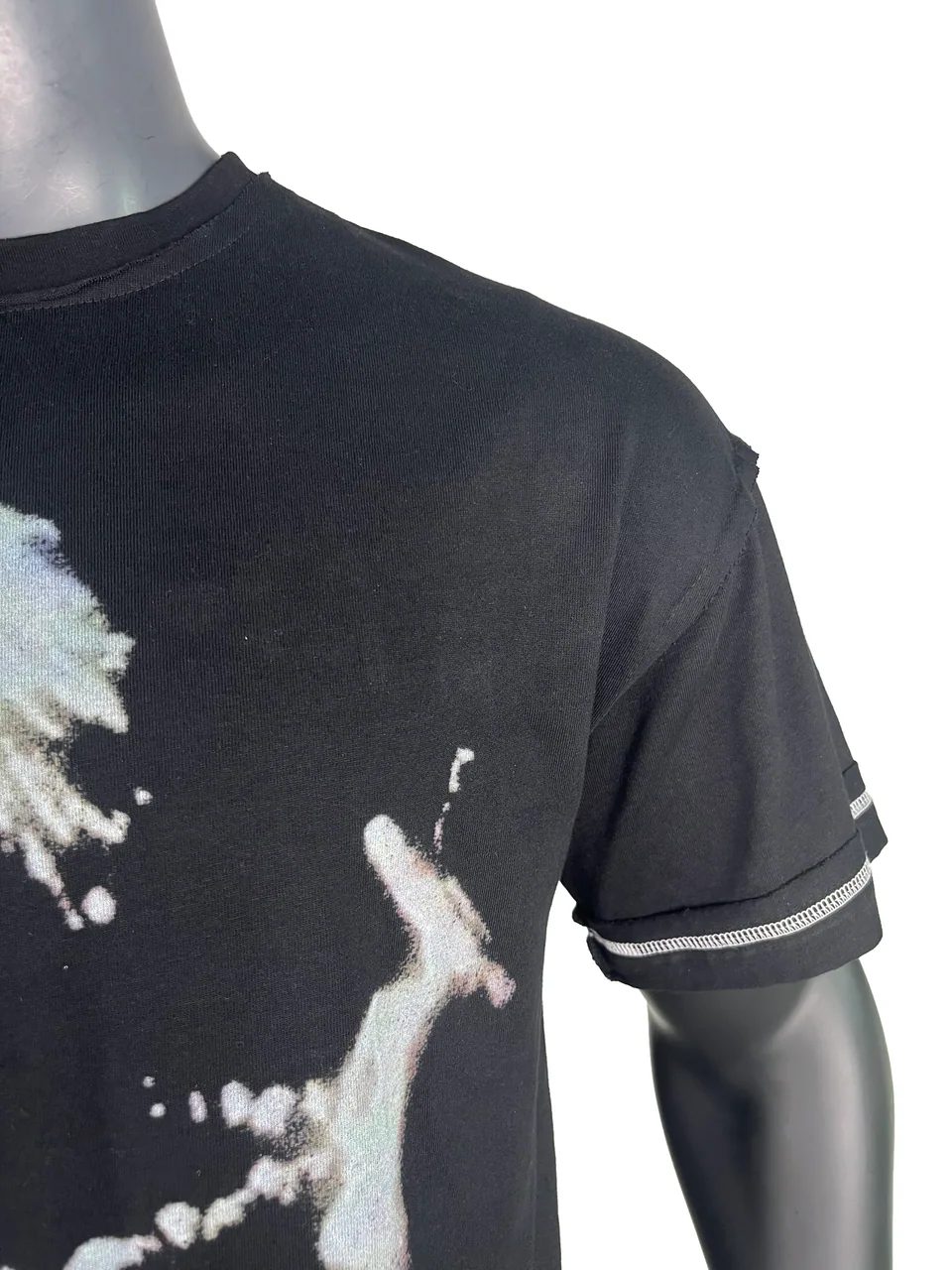 Close-up of a black T-shirt neckline, shoulder seam and contrast sleeve stitching